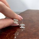 Dettaglio orecchini a bottone in Argento 925 a forma di C con zirconi luminosi